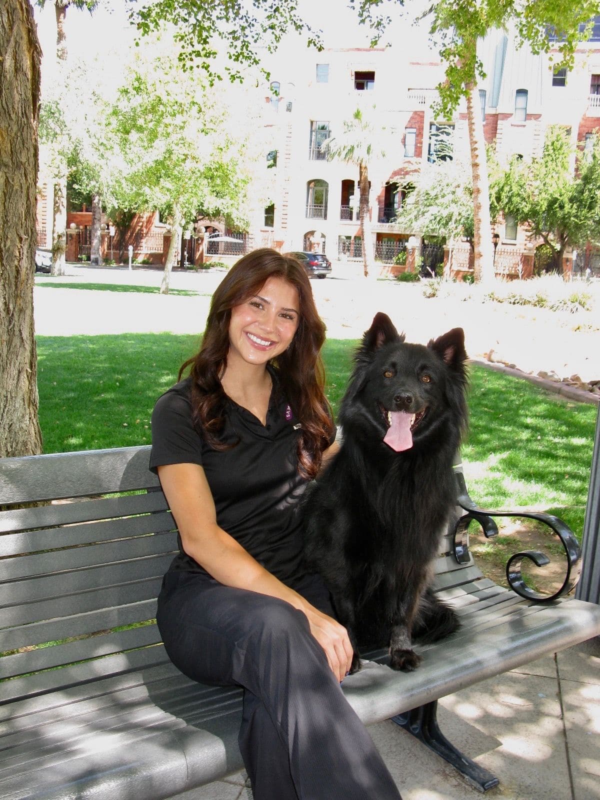 Sam’s Happy Tails trainer on a park bench with a dog